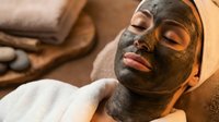 Young woman relaxing with natural clay face mask at luxury spa, enjoying skincare treatment for healthy glowing skin and wellness rejuvenation.