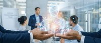 Team of diverse professionals in business attire joining hands over glowing digital network interface, symbolizing collaboration, unity, and connected teamwork in modern corporate environment.