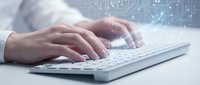 Professional hands typing on white keyboard with digital circuit board overlay representing technology and programming concepts in modern workspace.