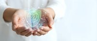 Close-up of hands holding glowing green shield with leaf icon, representing data protection, cybersecurity, and eco-friendly digital safety solutions for business.