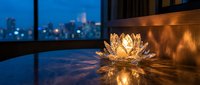 Golden lotus flower candle holder glowing on modern balcony with city skyline at dusk creating peaceful meditation atmosphere for relaxation and mindfulness.