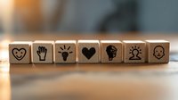 Wooden dice with emotional intelligence and psychology symbols arranged in row on blurred background, mental health and empathy concept for counseling.