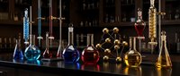 Chemistry laboratory with colorful liquids in glass flasks and beakers on dark table. Scientific research equipment for experiments and analysis.