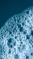 Ocean waves foam bubbles aerial view deep blue water surface texture natural pattern marine seascape for backgrounds and coastal design projects.