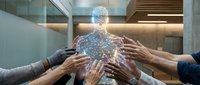 Diverse team of professionals joining hands around glowing digital human figure, symbolizing unity, collaboration, and shared vision in modern workplace environment.