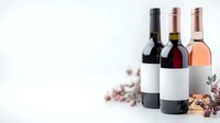 Wine bottles with blank labels on white background, featuring red, rose and dark varieties arranged with decorative autumn elements and dried flowers.