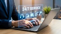 Businessman typing on laptop with glowing 24/7 service icons, representing round-the-clock customer support and online help desk solutions.