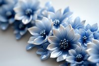 Delicate blue and white floral arrangement featuring handcrafted flowers with detailed petals and stamens on light background, creating soft romantic composition.