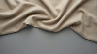 Luxurious beige silk fabric with elegant flowing folds and soft draping texture on neutral background for fashion and textile design projects.