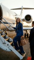Confident businesswoman in navy suit boarding private jet at sunset, luxury corporate travel and executive lifestyle for business success concepts.