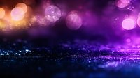 Magical purple and orange bokeh lights on dark glittery surface create dreamy abstract background with shallow depth of field and sparkling particles.