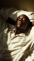 Young Black man relaxing in bed with eyes closed, wearing light cream-colored bedding, bathed in warm natural sunlight. Suitable for wellness, sleep, and lifestyle content.