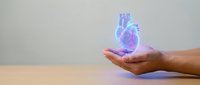 Holographic human heart floating above open palm showcasing medical technology and healthcare innovation in futuristic digital presentation.