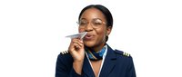Professional African American female airline pilot in navy uniform holding paper airplane with confident smile isolated on white background for aviation career concepts.