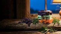 Handmade natural soap bars with lavender and herbs on rustic wooden surface in cozy evening light atmosphere for spa and wellness products.