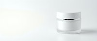 White cosmetic jar with silver cap on clean background for skincare product packaging and beauty brand marketing materials.