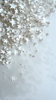 White paper stars scattered on light background creating dreamy corner composition with soft shadows and delicate depth effect for festive designs.