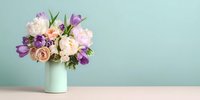 Fresh spring bouquet with purple tulips and cream roses in mint vase on pastel background with copy space for Mother's Day or wedding decor.