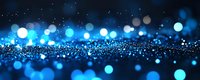 Blue glittering particles with bokeh lights creating magical sparkle effect on dark background for luxury design projects and festive decorations.