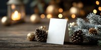Blank white card with pine cones and evergreen branches on rustic wooden table with warm bokeh lights creating cozy holiday atmosphere for greeting cards.