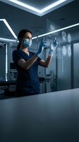Female doctor in scrubs and mask interacts with futuristic holographic brain scans in a modern hospital operating room.