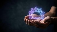 Hands holding glowing neon teamwork icon with connected people symbols on dark background, representing collaboration, unity, and business partnership for corporate communications.
