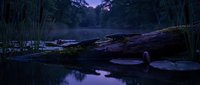 Tranquil forest stream at twilight with fallen log and rocks creating peaceful water reflection in purple evening light atmosphere.