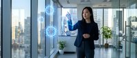 Professional Asian businesswoman interacting with holographic digital interface in modern glass office with city skyline view for technology presentations.