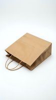 Brown kraft paper shopping bag with twisted handles isolated on white background for retail packaging and eco-friendly branding designs.