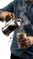 Man in denim shirt pouring hot steaming coffee from French press into eco cup, with flying coffee beans on white background.