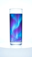 Glass of vibrant blue and purple liquid with glowing swirled patterns, isolated on white background. Perfect for beverage, drink, and refreshment design projects.