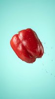 Fresh red bell pepper with water droplets isolated on turquoise background, suitable for food packaging, recipe blogs, and culinary design projects.