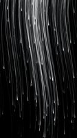 Heavy rainfall streaks cascade diagonally across dark background, creating dynamic motion effect. Monochrome weather pattern suitable for storm, climate, and atmospheric design projects.