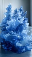 Ethereal blue ink swirls in water creating dynamic fluid art formations with translucent layers and organic shapes against dark background, suitable for creative design projects.