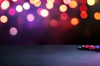 Colorful defocused lights create magical bokeh effect above casino poker chips on dark surface, setting dramatic mood for gaming and entertainment background.