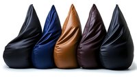 Modern bean bag chairs in black, navy blue, tan brown and dark brown leather arranged in row on white background, isolated furniture design elements.