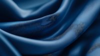 Luxurious navy blue silk fabric with elegant folds and gentle waves creates soft shadows and highlights, suitable for fashion and luxury product backgrounds.