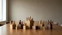 Wooden peg figures standing on cube pedestals arranged on a table, symbolizing teamwork, community, and organizational hierarchy in business concepts.