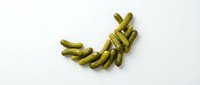 Isolated pickled gherkins arranged in curved pattern on white background, ready for food packaging, recipe blogs, culinary design, and restaurant menus.