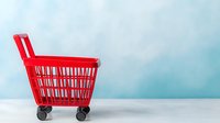 Empty red shopping basket on wheels against soft blue background with copy space, minimalist retail and commerce concept for marketing materials.