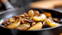 Sauteed mushrooms and onions caramelizing in black cast iron pan, close up view showing golden brown edges and rich textures in warm lighting.