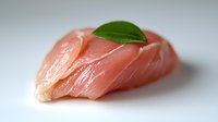Fresh raw tuna sashimi slices garnished with green leaf on white background, close-up view showing tender pink meat texture for Japanese cuisine.
