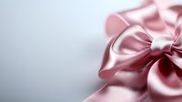 Elegant pink satin bow with soft folds and delicate texture against light background, creating romantic and feminine composition for gift wrapping and decoration.
