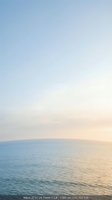 Serene ocean horizon with soft pastel sky gradient at golden hour creating peaceful seascape for meditation and wellness content.