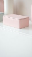 Pastel pink matte rectangular box with lid on a white surface, soft minimalist home decor styling for storage and organization concepts.