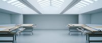 Modern hospital morgue interior with metal examination tables under natural skylight illumination for medical facility design and healthcare architecture concepts.