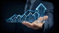 Professional in dark suit holds glowing blue holographic chart showing upward trend with cityscape silhouette, representing business growth and success in digital era.