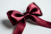 Elegant burgundy satin ribbon bow with soft texture and delicate folds against white background, suitable for gift wrapping, wedding decor, and holiday celebrations.