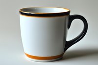White ceramic mug with black handle and orange trim stripes, isolated on neutral background. Suitable for product mockups, merchandise design, and promotional materials.