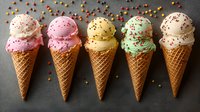 Colorful ice cream scoops in waffle cones arranged in row with sprinkles scattered around on dark background, featuring vanilla, strawberry, and mint flavors.